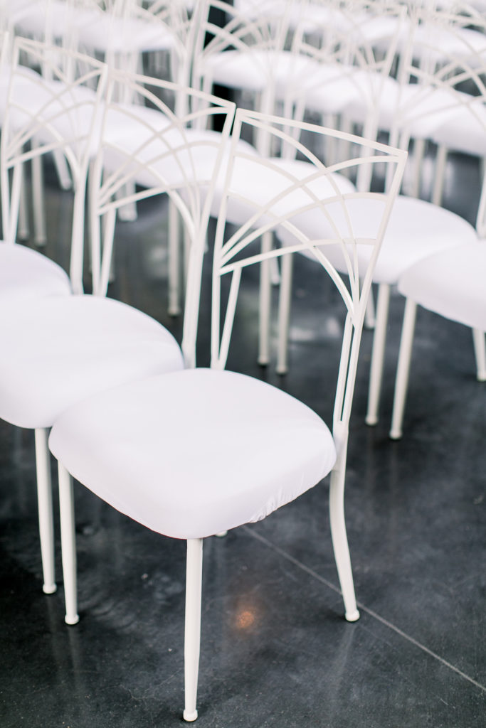 Elegant white chairs in rows as part of a new venue started by Lindsay Lucas.
